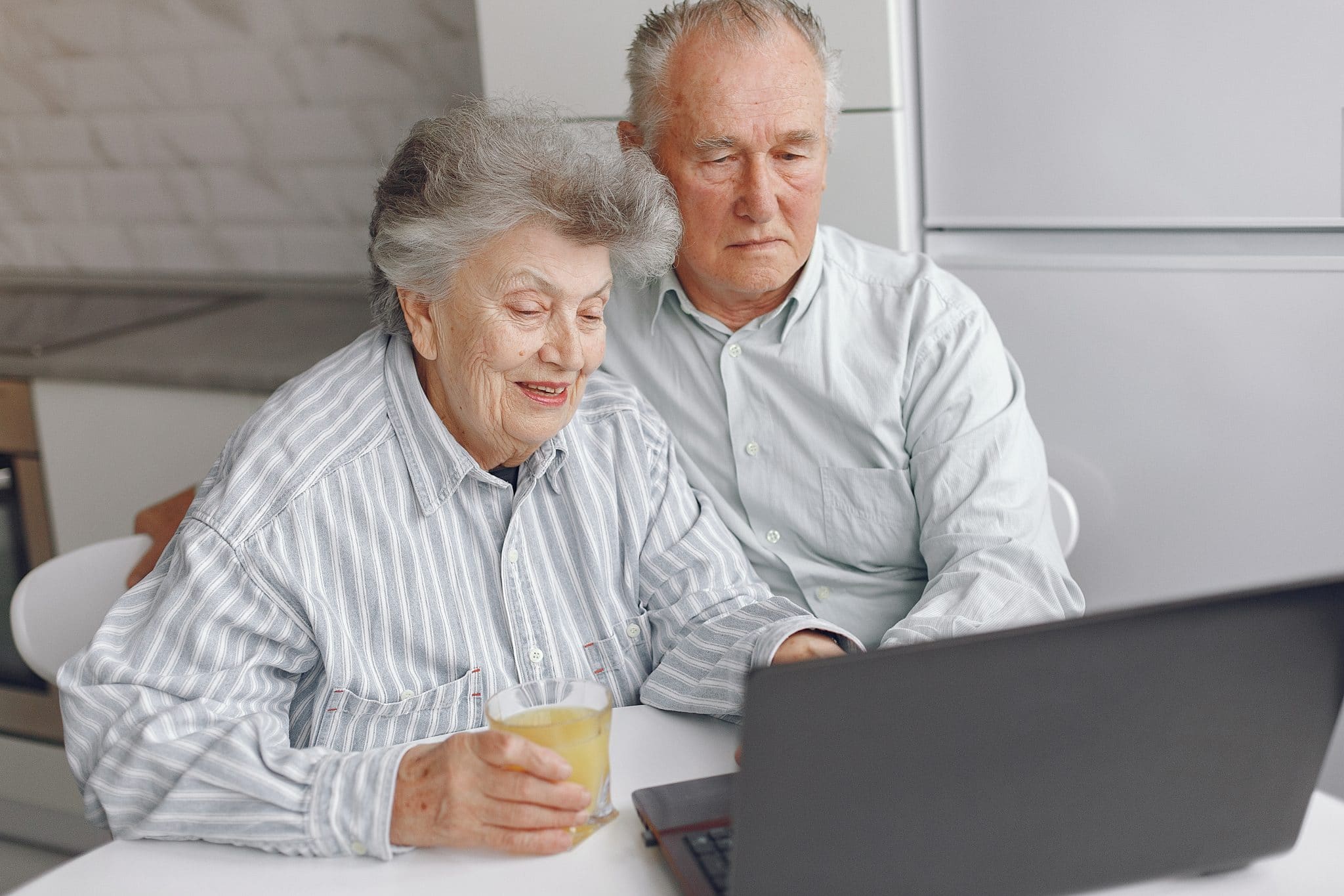 elegant old couple sitting home using laptop 2